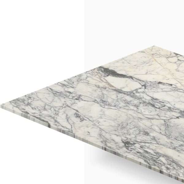 Corner view of a white marble countertop with gray veining. Leveled edge visible at the bottom left and diagonal perspective.