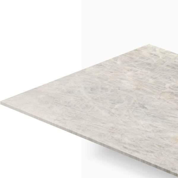 Corner of a light beige marble tabletop seen from an angle against a white background.