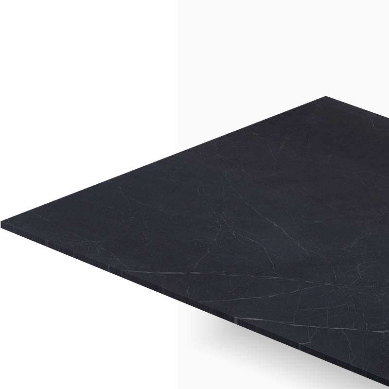 Close-up of a dark marble tabletop angled across a white background, showing subtle veining and edge detail.