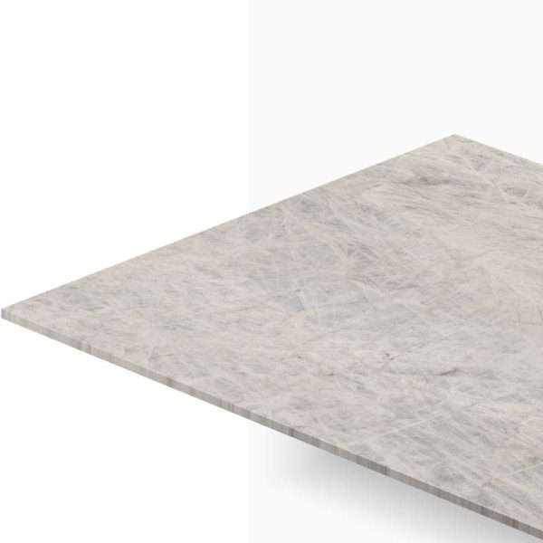 Angled close-up of a pale gray marble countertop slab with a visible edge and veining patterns